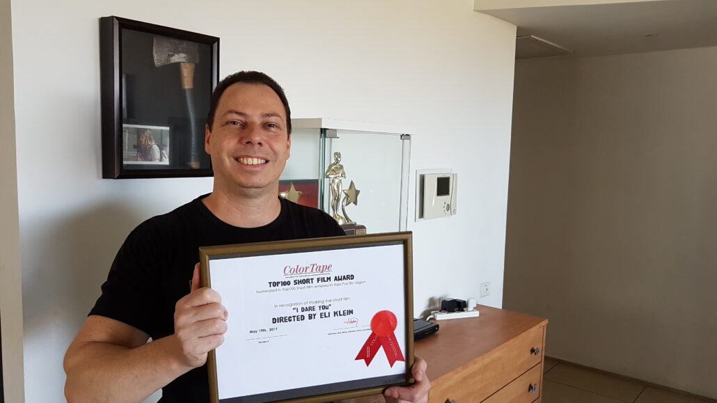 Eli Klein holding the ColorTape International Film Festival Top 100 Short Film award for I Dare You